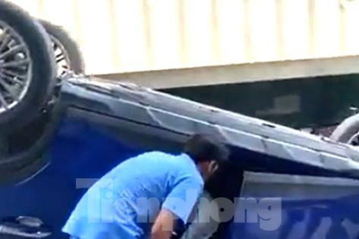 Giải cứu nữ tài xế trong ô tô mất lái lật ngửa giữa đường - Báo Tiền Phong
